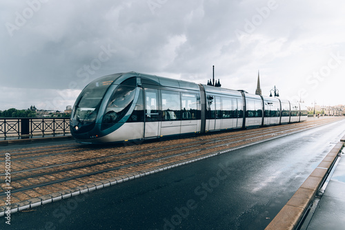 Modern city tram crossing bridge after rain photo