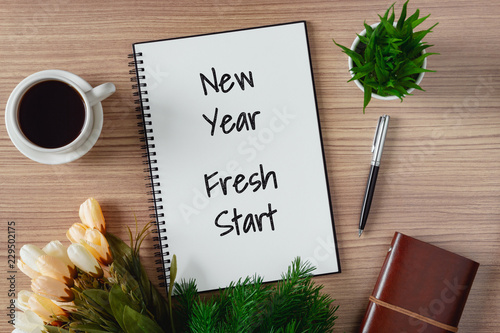 Notepad with wish list and coffee cup. New year's hope and resolution concept - New Year, Fresh Start. photo