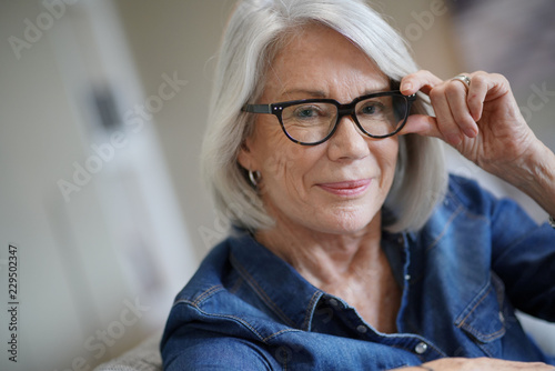  Attractive senior woman at home with eyeglasses
