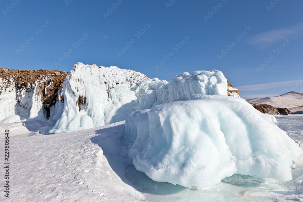Unusual winter landscape with icy white rocks on the frozen Lake Baikal at a sunny day of February