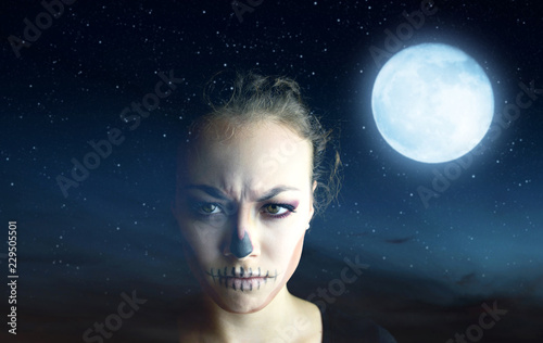 Woman with Halloween makeup, in the background night sky with moon.