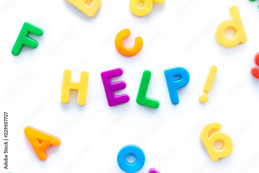 Help spelled with colorful magnetic letters on a white background Help spelled with colorful magnetic letters on a white background