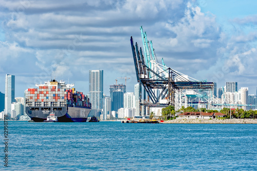 Fotografia, Obraz Tug guiding container ship into Port Miami