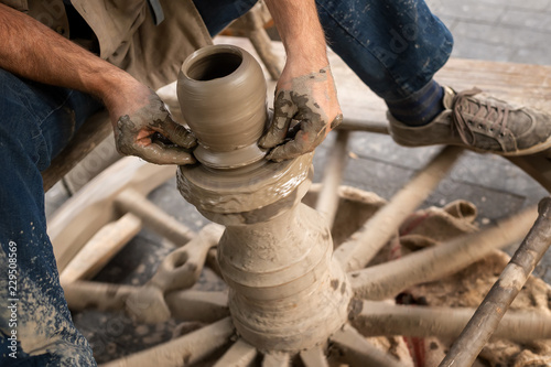 Fototapeta Naklejka Na Ścianę i Meble -  Potter hands makes on the pottery wheel clay pot