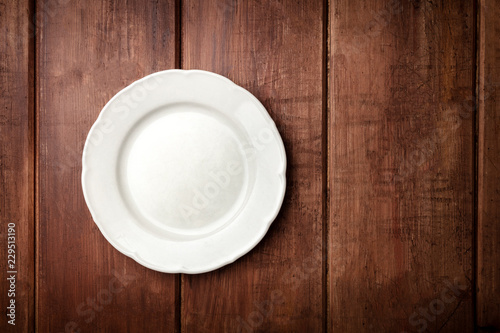 White plate, shot from above on a dark rustic wooden background with a place for text