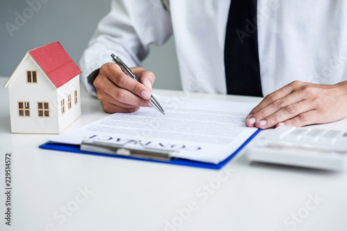 Man sign a home insurance policy on home loans, Businessman signing contract insurance