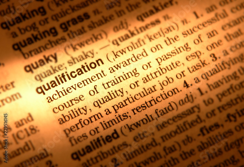 CLOSE UP OF DICTIONARY PAGE SHOWING DEFINITION OF THE WORD QUALIFICATION
