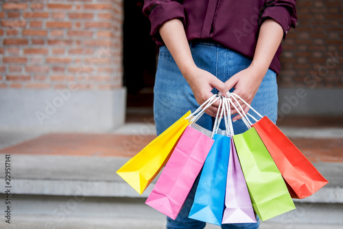 Consumer and shopping lifestyle concept, Happy young woman standing and holding colorful shopping bags enjoying great day in shopping