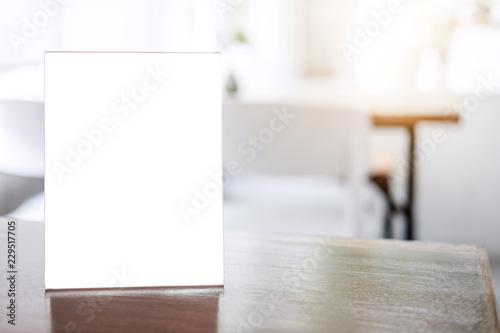 Mock up blank menu frame on table in coffee shop stand for your text of display your product photo