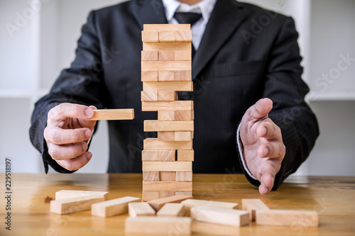 Alternative risk concept, plan and strategy in business, Risk To Make Business Growth Concept With Wooden Blocks, Images of hand of business people placing and pulling wood block on the tower