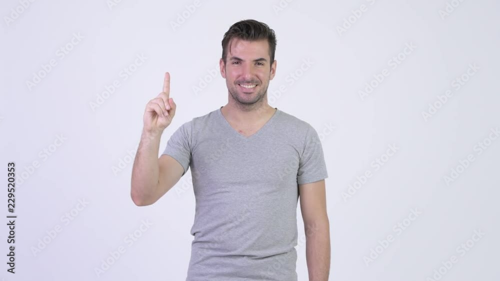 Young happy Hispanic man smiling while pointing up Young happy Hispanic man smiling while pointing up
