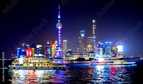 Photography colorful lights and futuristic skyline and boats on river of shanghai pudong sky