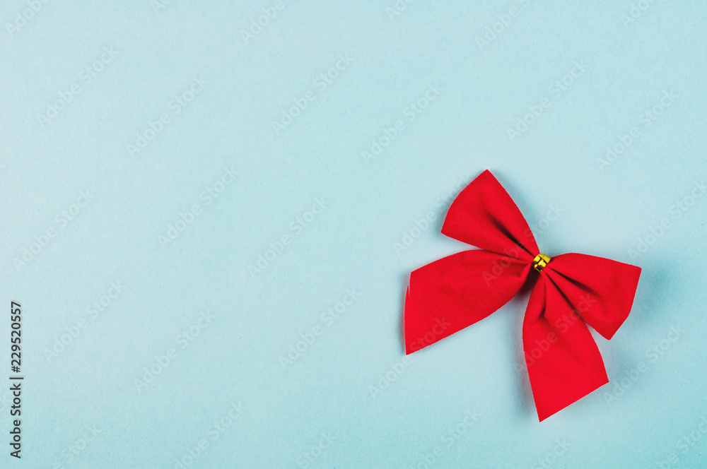Single red tied bow on blue background with copy space for your text Single red tied bow on blue background with copy space for your text