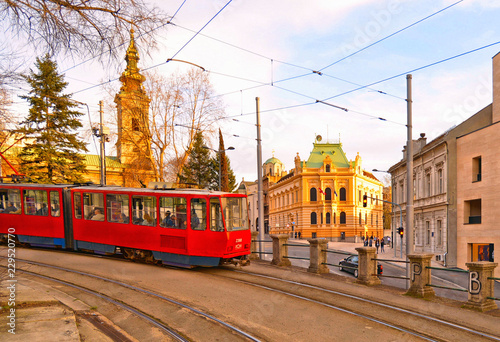 colorful facade of old architecture bildings, cathedral tower and old red tram on the street of Belgrade, Serbia