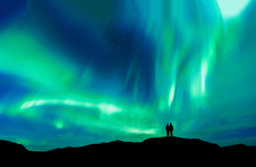 Leinwandbilder Nordlichter Romantisches Paar unter Polarlicht Berggipfel  © basiczto