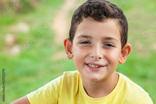 Portrait of happy smiling child boy outdoors. Concept of happy family or successful adoption or parenting.