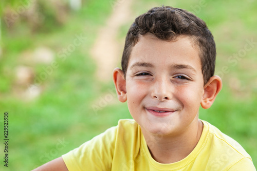 Portrait of happy cute child boy outdoors. Concept of happy family or successful adoption or parenting.