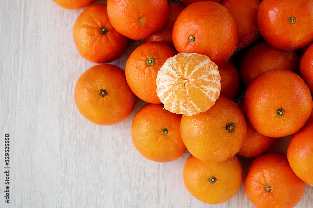 Background many tangerines and one without peel Background many tangerines and one without peel