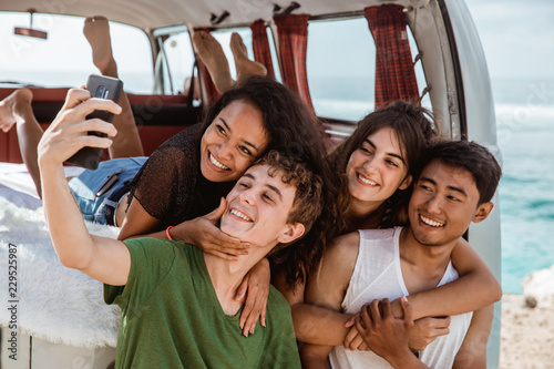 Selfie concept, hugging boyfriend from back at retro van