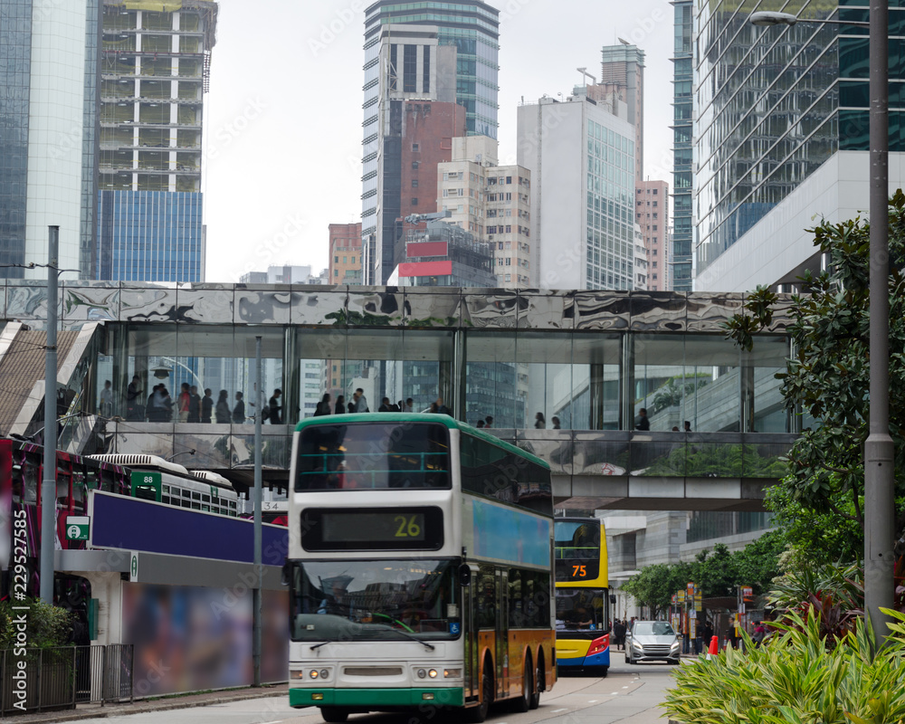 Busy city street,  double-decker trams, day in big town, urban life. Daily routine, intensity of streets in Hong Kong.