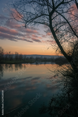 Colorful sky with reflections in the water of the river Mures, Romania © Menyhert