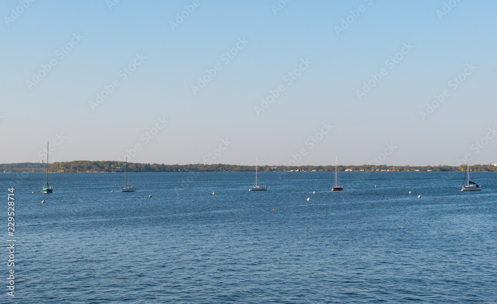 MADISON, WISCONSIN - MAY 07, 2018: Sailboats anchored in a line on Lake Mendota.