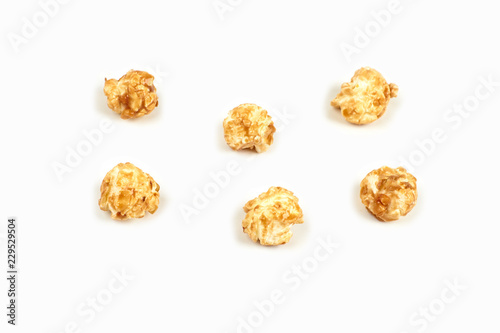 Few pieces caramel popcorn on white background.
