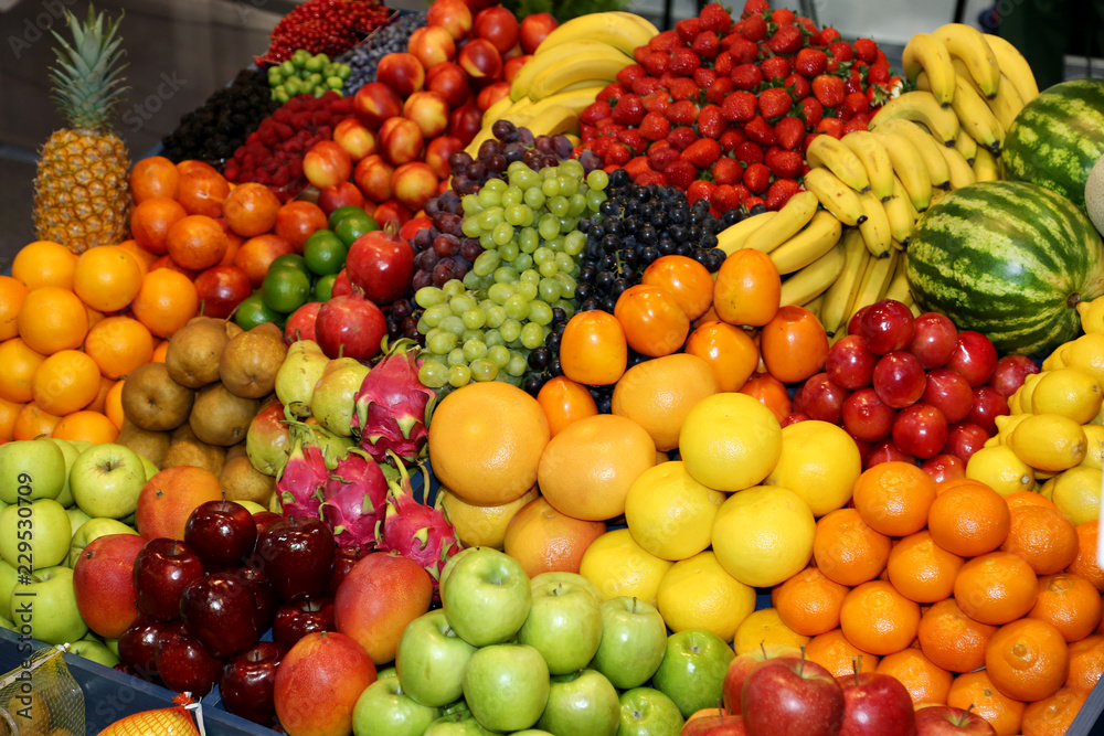 Farmers market with various colorful fresh healthy fruits for sale. A big choice of ripe various fresh fruits  on market