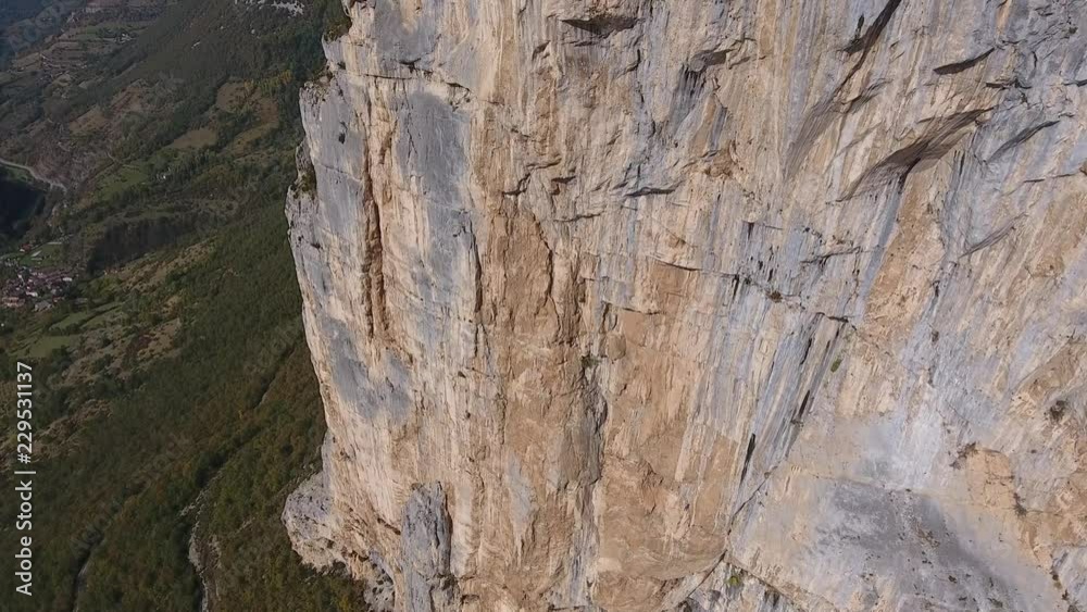Aerial shot flying along a cliff in vercors massif, discovering three man on the top. Sunny day in choranche france. Aerial shot flying along a cliff in vercors massif, discovering three man on the top. Sunny day in choranche france.