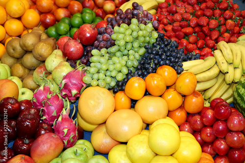 Farmers market with various colorful fresh healthy fruits for sale. A big choice of ripe various fresh fruits on market