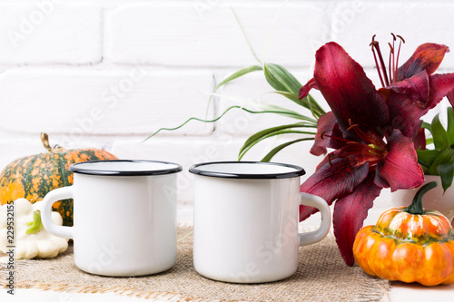 Fototapet Two white campfire enamel mug mockup with pumpkin and lily