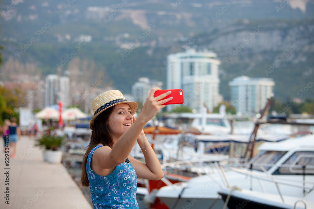 Europe travel selfie, cute happy smiling tourist girl taking self-portrait picture with smartphone during summer vacation in famous European Mediterranean destination.