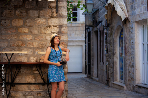 Young attractive cheerful travel girl walking with camera in old Mediterranean city. Summer travel concept © Nickolay Khoroshkov