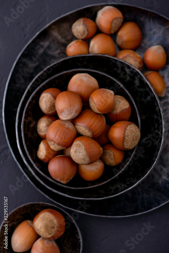 Hazelnuts in metal plate. Nuts on dark background