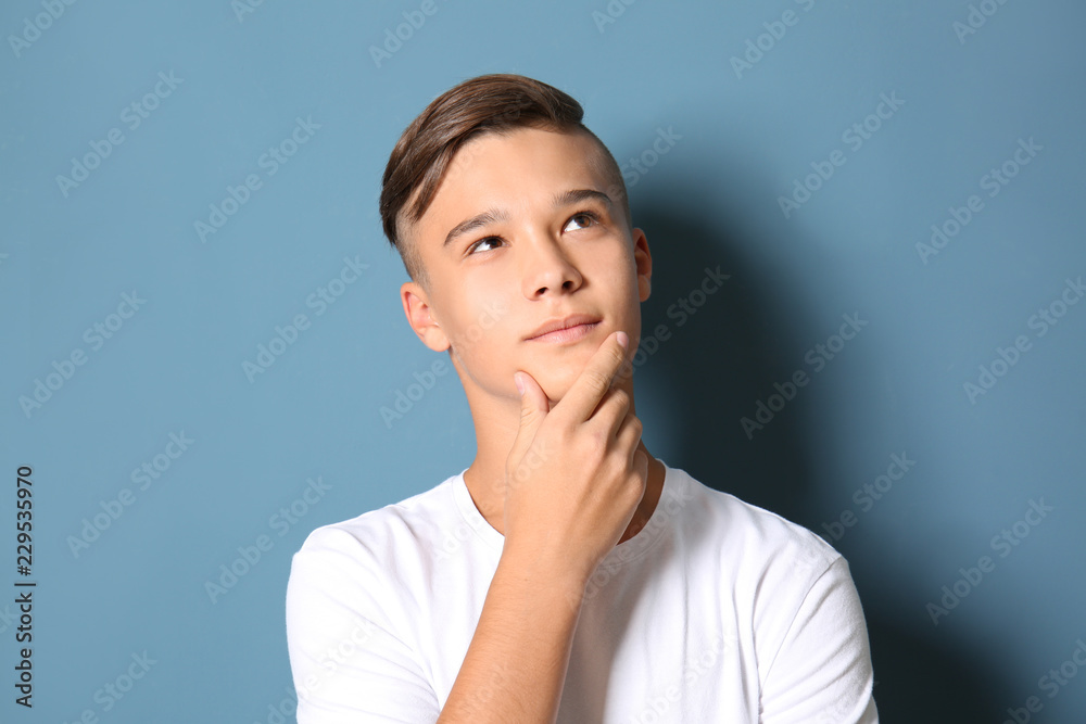 Thoughtful teenage boy on color background Thoughtful teenage boy on color background