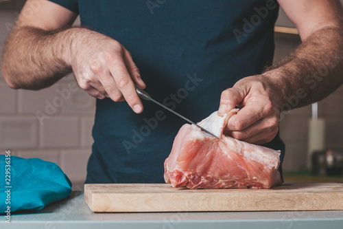 A man is engaged in cooking meat, cooking at home
