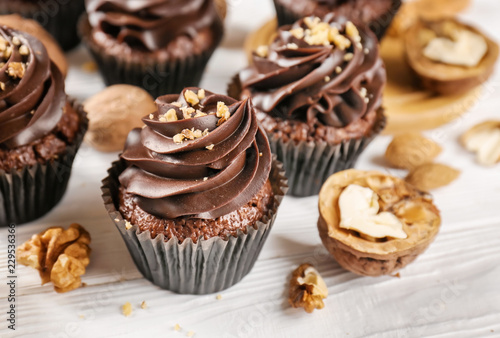 Chocolate cupcakes and walnuts on wooden table