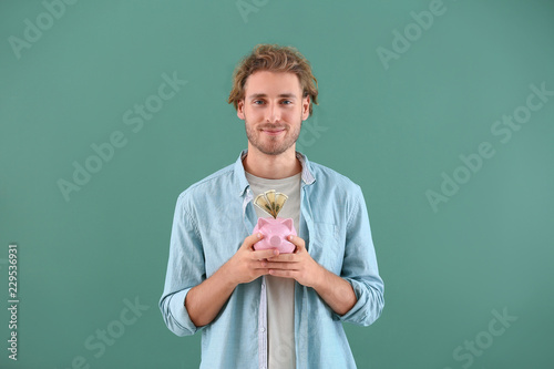 Handsome man with piggy ban...