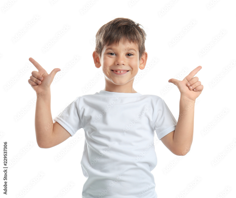 Cute little boy in t-shirt pointing at something on white background