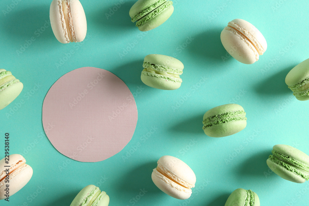 Fresh tasty macaroons and blank card on color background Fresh tasty macaroons and blank card on color background