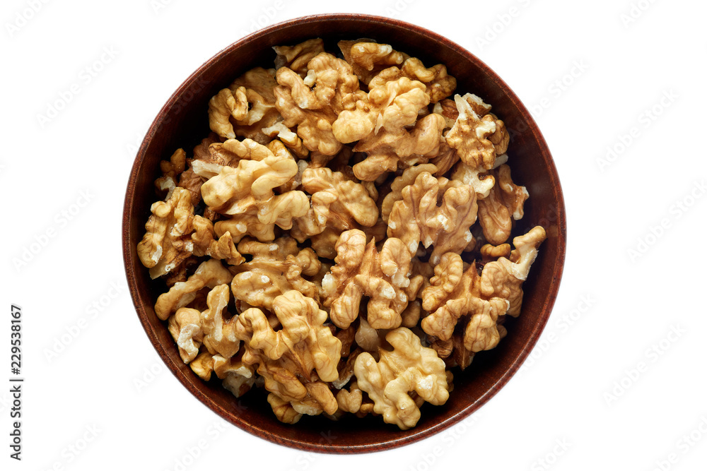 Walnut kernels in wooden bowl isolated on white background