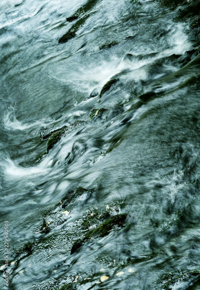 Powerful flow of water over the stones, close-up