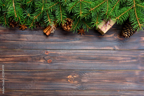 gift boxwith cinnamon sticks, anise stars, pine cones and pine branches on wooden table. Top view. Christmas gifts in woodan style