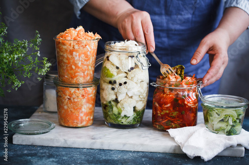 Fermented preserved vegetarian food concept. Cabbage kimchi, broccoli marinated, sauerkraut sour glass jars