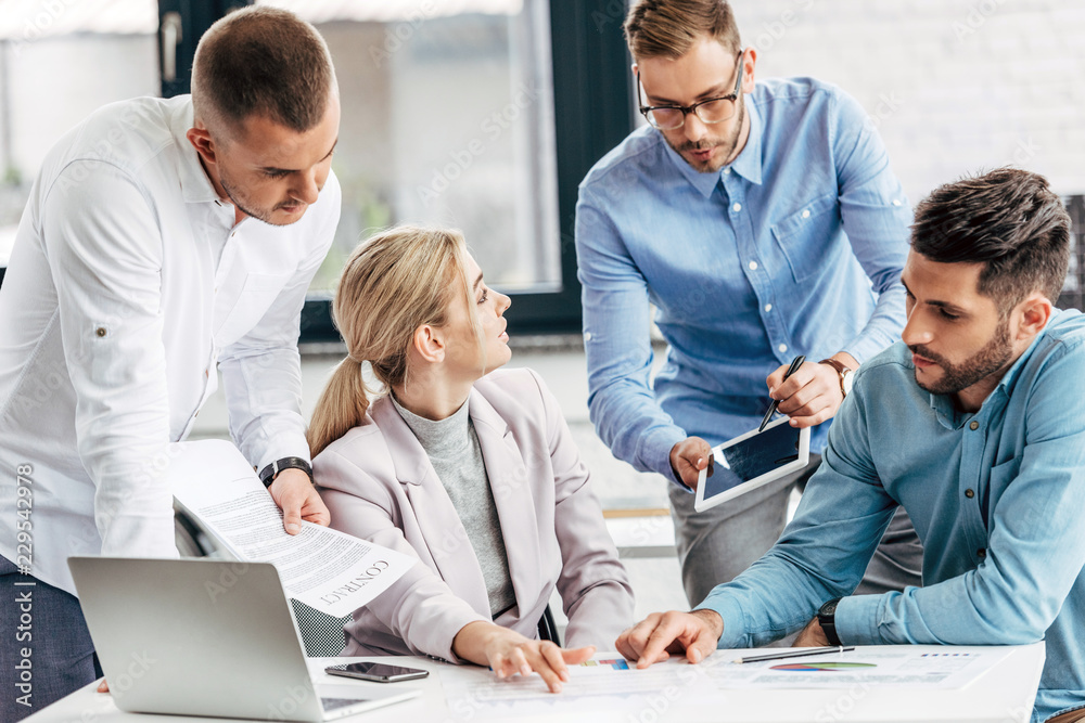 young businesswoman working with male colleagues in office young businesswoman working with male colleagues in office