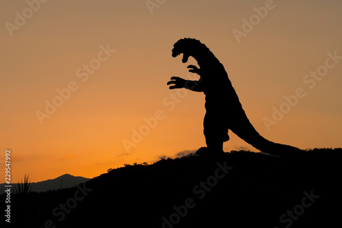 Godzilla-artiges Monster als schwarze Silhouette auf einem Berg