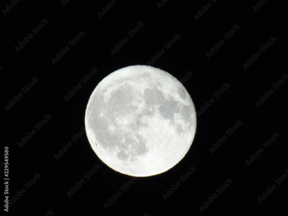Obraz premium An amazing caption of the full moonlight over the city by night in summer days with some clouds and foggy
