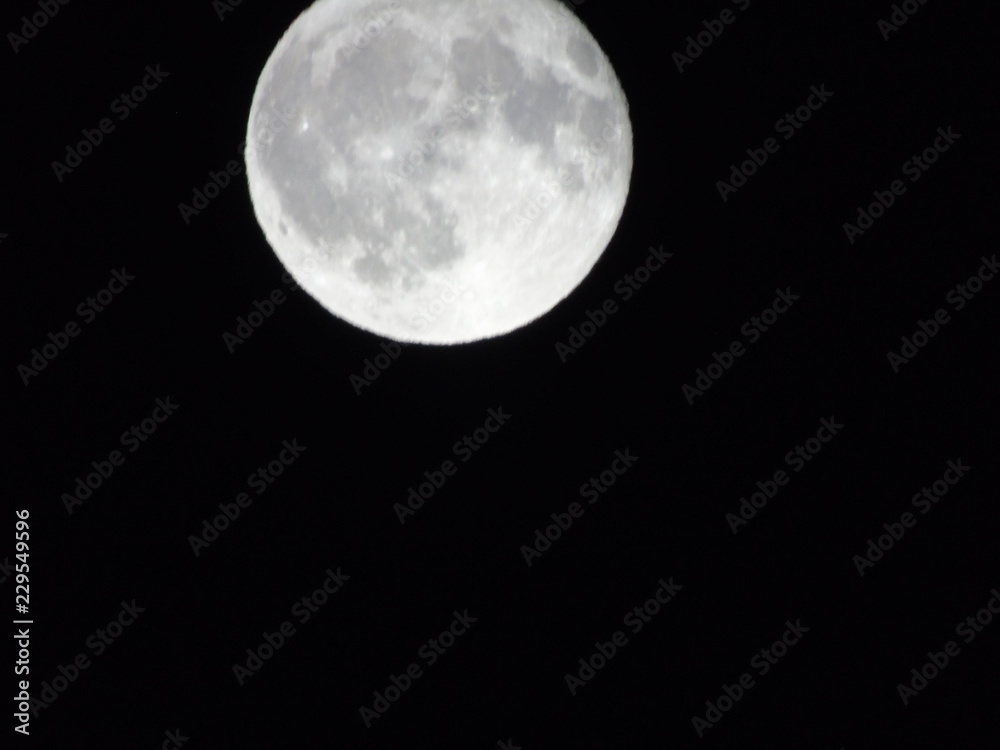 Obraz premium An amazing caption of the full moonlight over the city by night in summer days with some clouds and foggy