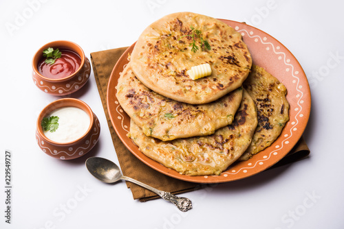 Aloo Paratha / Indian Potato stuffed Flatbread. Served with fresh curd and tomato ketchup. selective focus