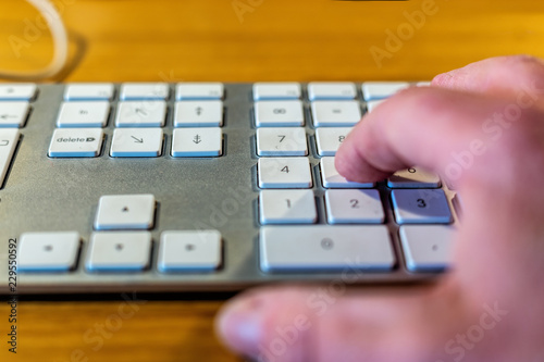 Hand som skriver siffror på ett tangentbord photo